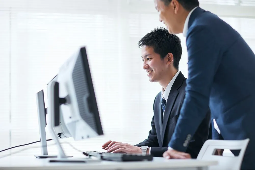 パソコンを触って笑顔の男性
