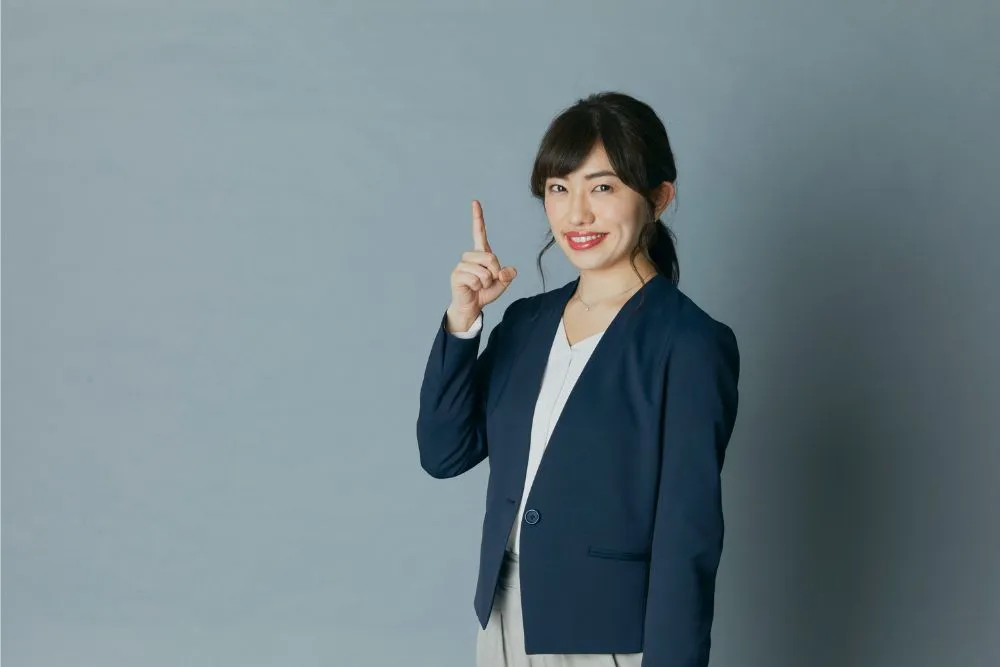 指を立てる女性